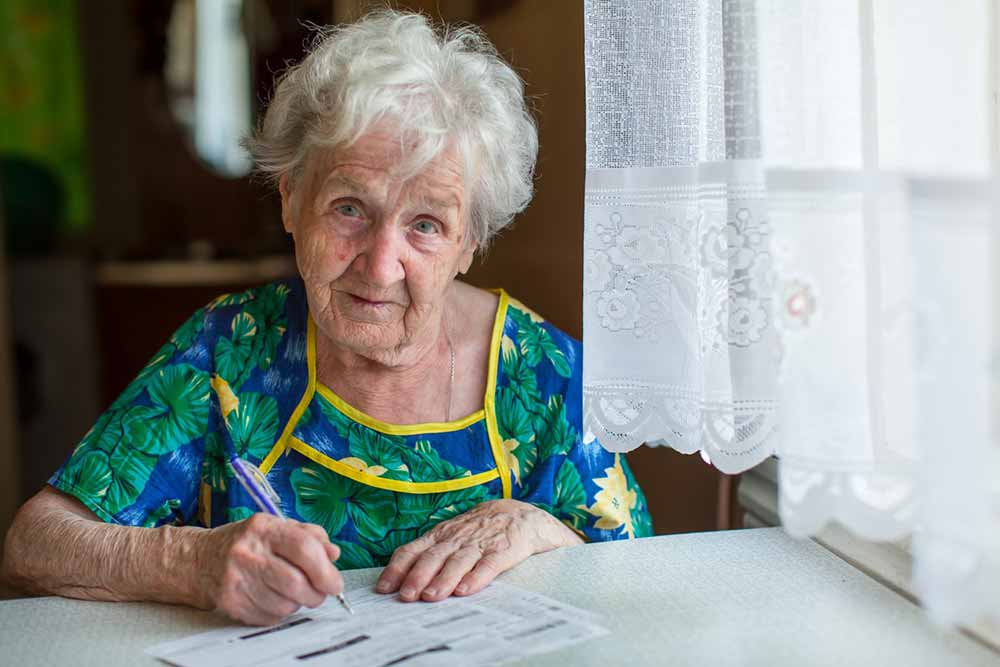 Pensioner completing form writing